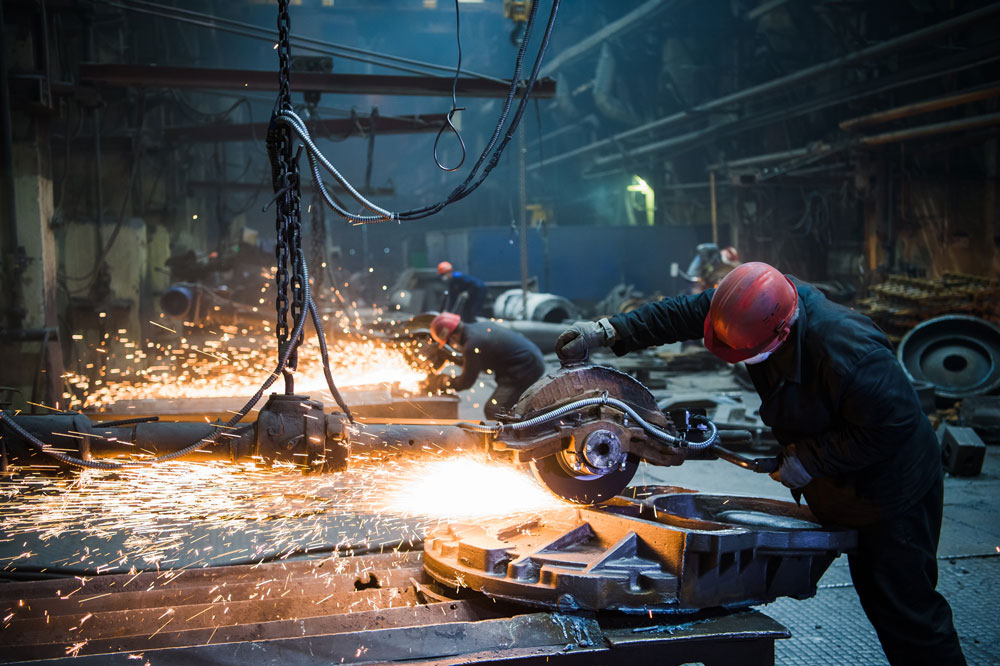 workers grinding metal in factory