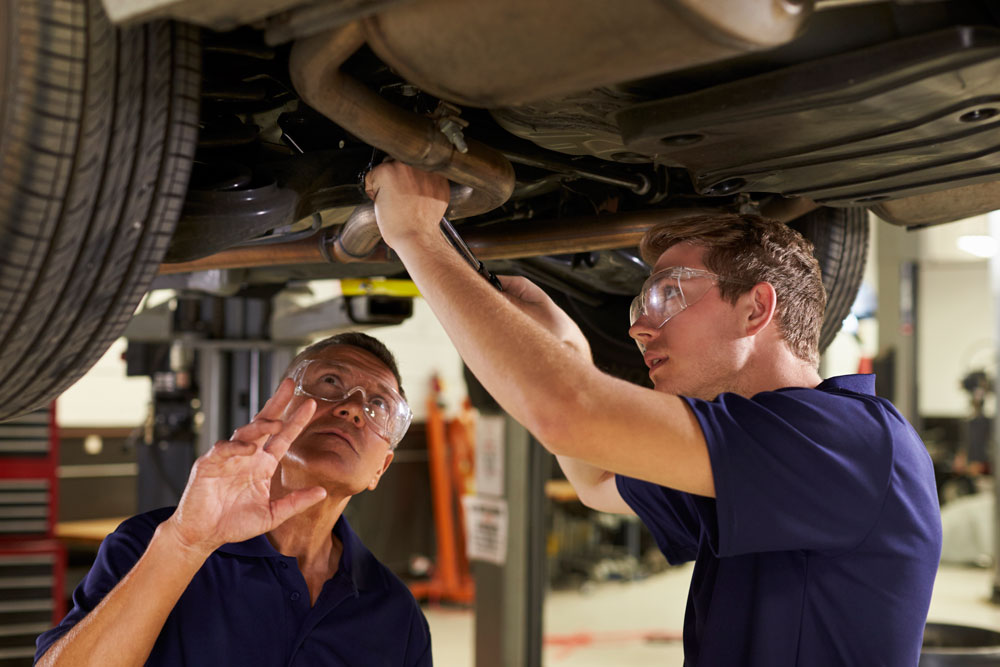 student and teacher working on vehicle